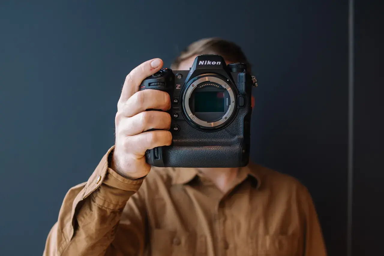 Osoba trzyma aparat Nikon Z9, zasłaniając twarz. Trwa test tego profesjonalnego sprzętu.