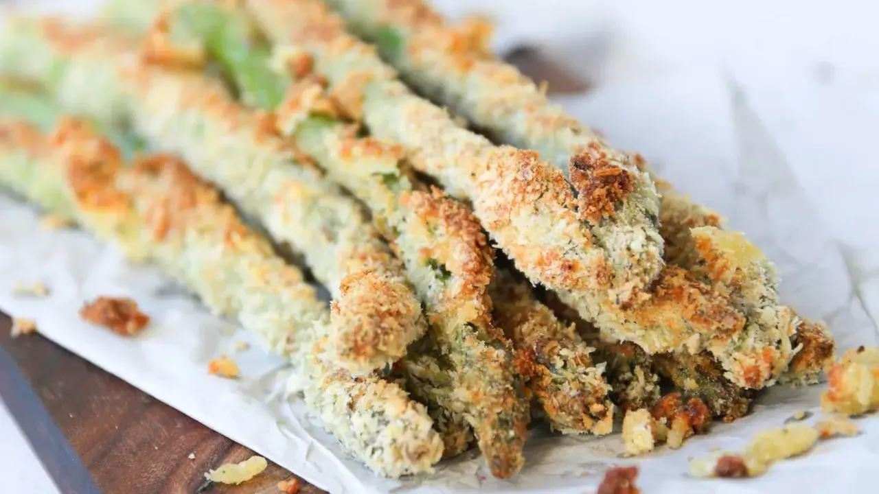 Espárragos verdes crujientes, empanizados y horneados, listos para disfrutar como aperitivo saludable.