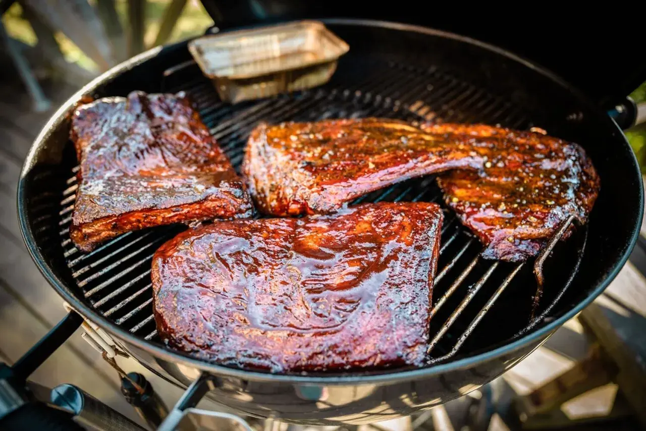 Saftiga revbensspjäll med glaze som steker på grillen. En härlig sommarmåltid som doftar fantastiskt.
