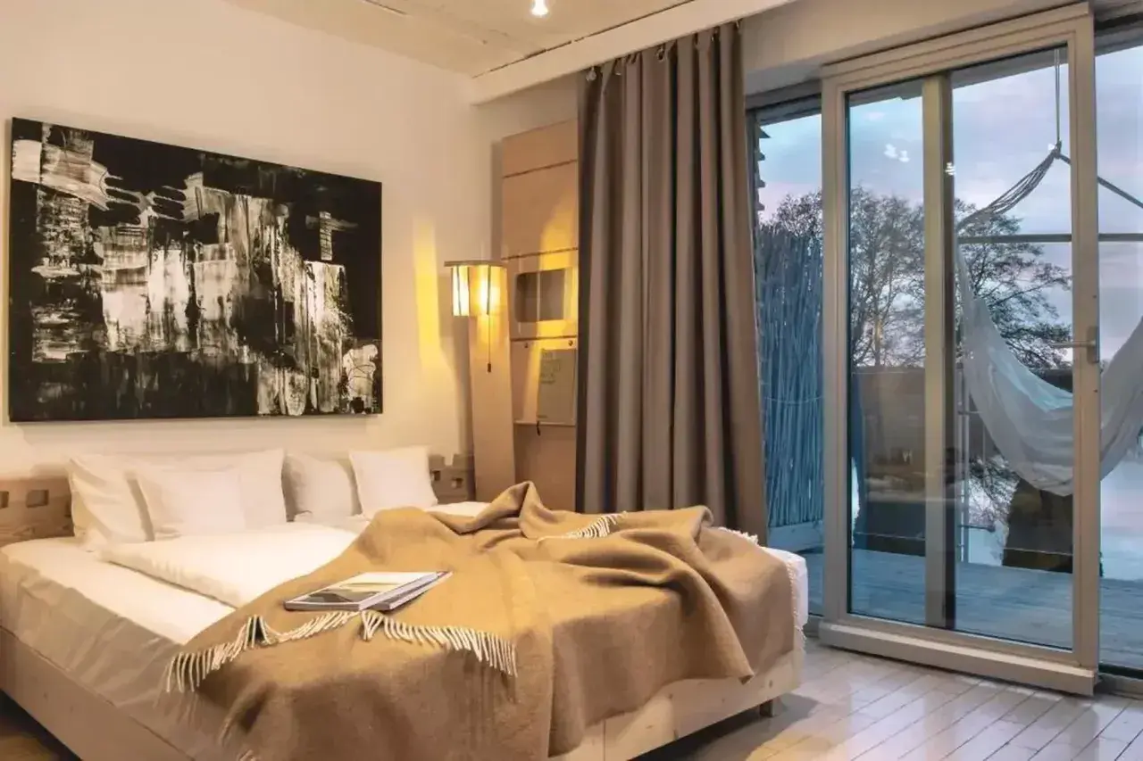 Przytulny pokój w hotelu butikowym. Co to jest? To miejsce z wygodnym łóżkiem, sztuką i widokiem na naturę.