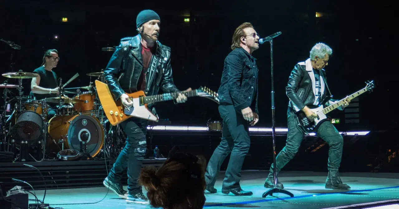 Bono śpiewa, The Edge gra na gitarze, a Adam Clayton na basie. Ich muzyka to pieśń protestu, która porusza tłumy.