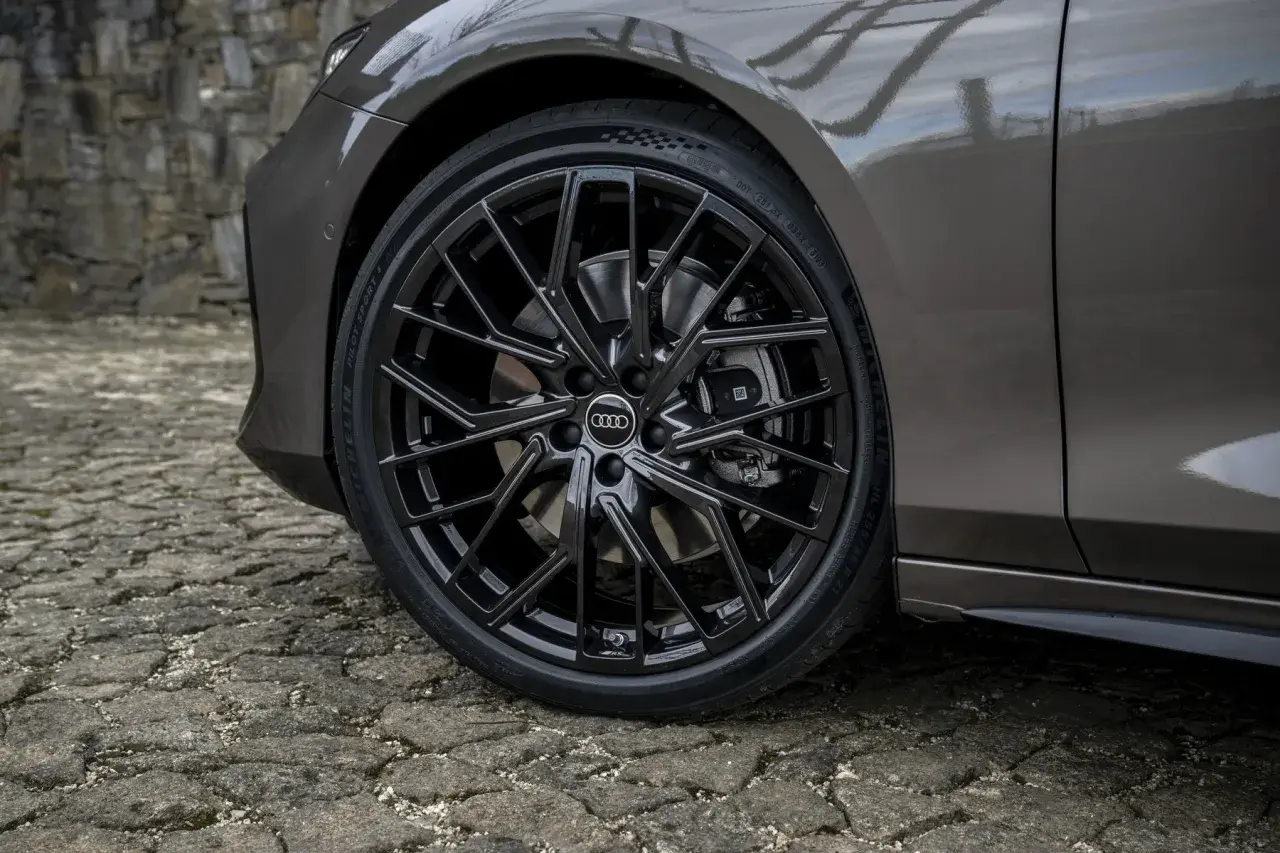 Błyszczące, czarne felgi Audi z homologacją opon Michelin Pilot Sport 5 na kamiennej nawierzchni.