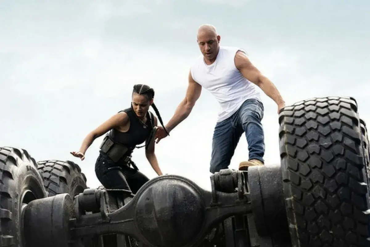 Dominic Toretto pomaga Letty Ortiz wstać na przewróconym pojeździe w scenie z Szybcy i wściekli 9.
