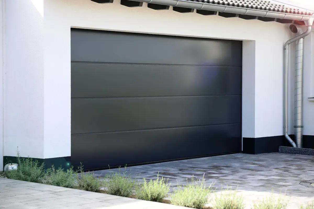 Modern mörkgrå garageport med horisontella linjer. Perfekt för dig som vill byta garageport och uppgradera husets utseende.