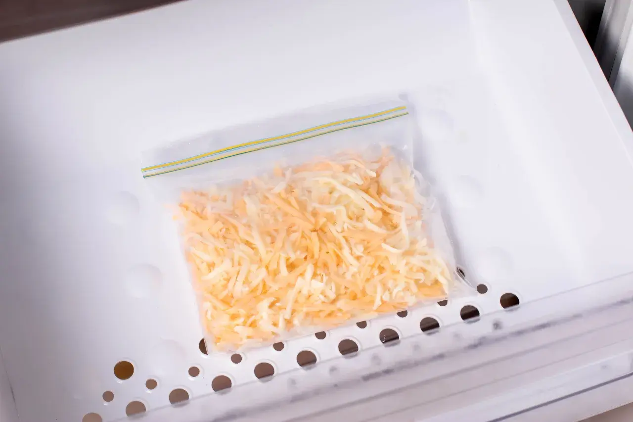 Sacchetto con formaggio grattugiato pronto per essere congelato. Si può congelare il formaggio grattugiato per averlo sempre a disposizione.