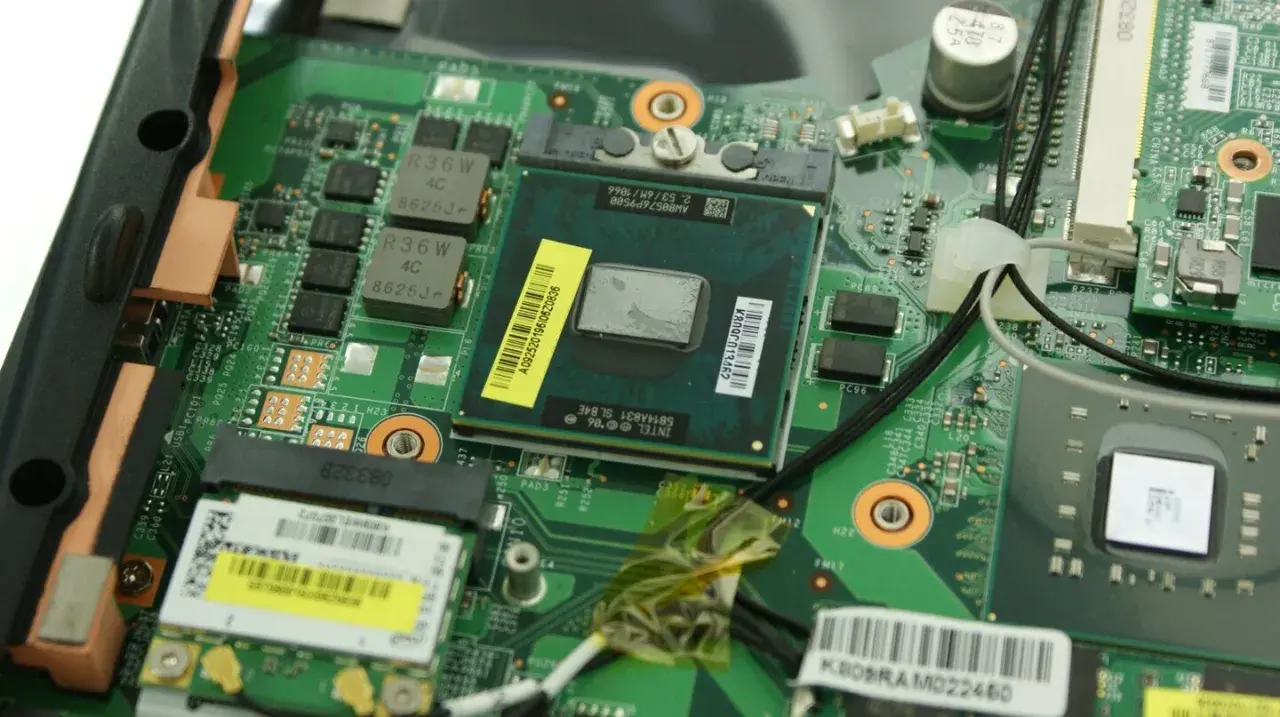 Nahaufnahme eines geöffneten Laptops, bereit für den **laptop cpu wechseln**. Der Prozessor ist sichtbar, umgeben von grüner Platine und Kabeln.