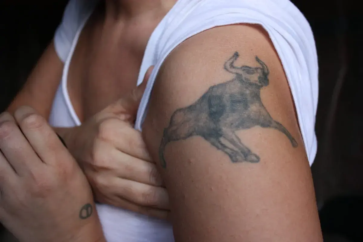 Mały tatuaż byk na ramieniu, symbol siły i odwagi.