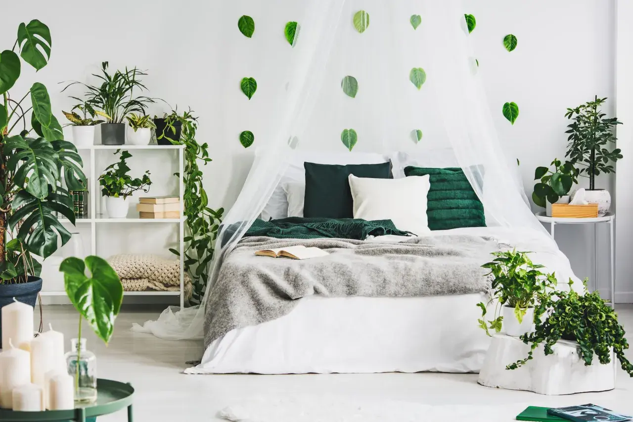 Ein Schlafzimmer im Stil "urban jungle ideen" mit vielen Pflanzen, einem Himmelbett und grünen Akzenten.