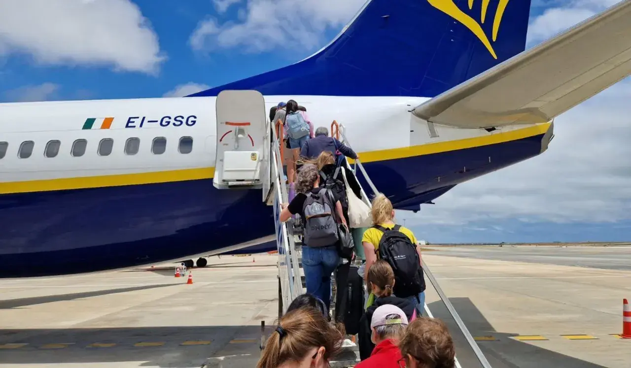 Pasażerowie wchodzą po schodkach do samolotu Ryanair. Czy to opłata transakcyjna Ryanair?