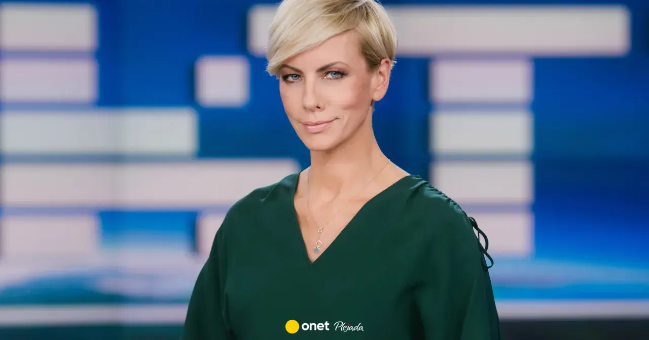 Anita Werner w zielonej sukience, z krótkimi blond włosami, na tle niebiesko-białej grafiki.