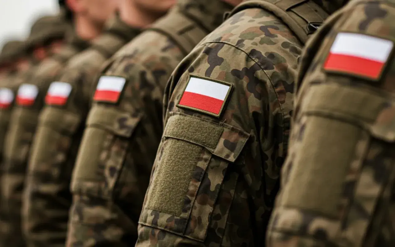 Żołnierze w mundurach moro z polskimi flagami na ramionach, gotowi na wezwania do wojska.