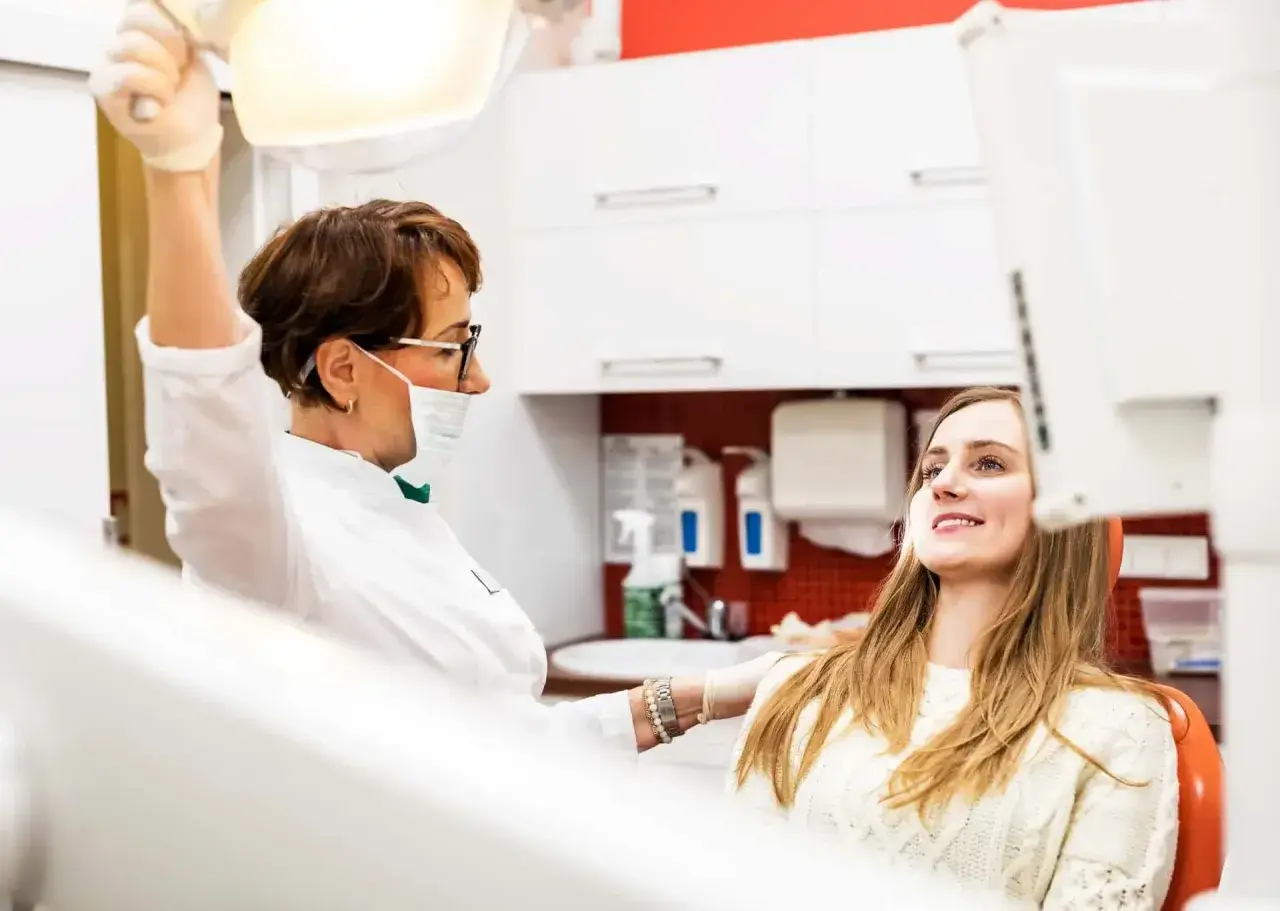 Dentystka przygotowuje się do chirurgicznego usuwania ósemki w ciąży. Pacjentka uśmiecha się, ufając profesjonalistce.