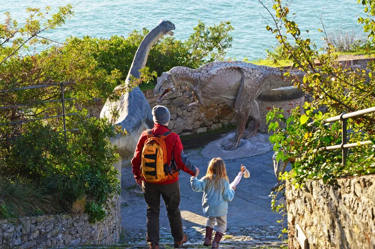Un padre e una bambina esplorano dinosauri in Liguria, un'avventura indimenticabile per tutta la famiglia.