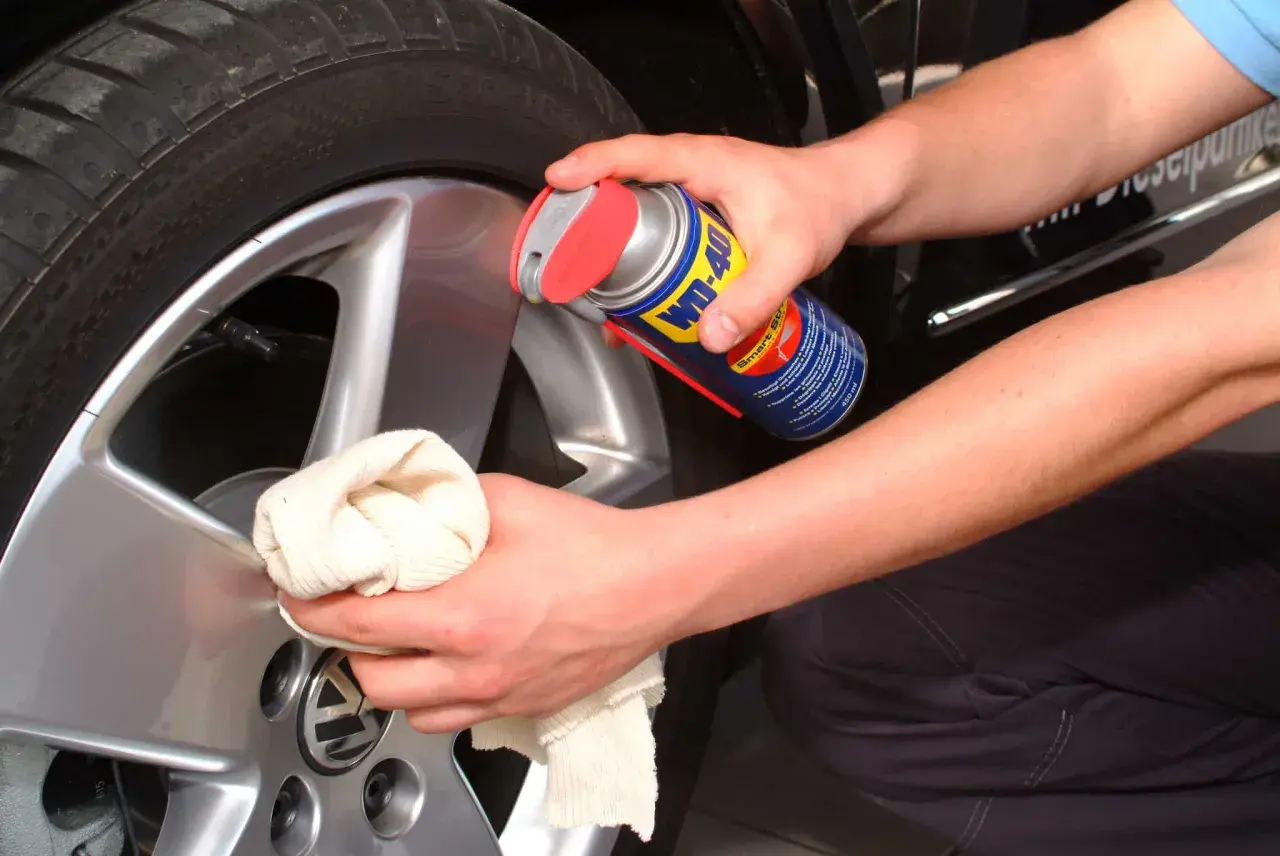 Hände reinigen Felgen mit WD-40 und Tuch. Ein einfacher felgenreiniger hausmittel-Trick für glänzende Alufelgen.