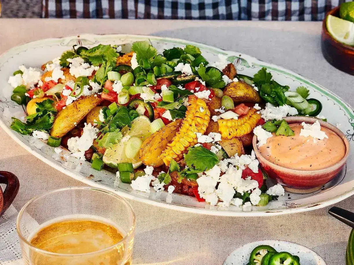 En härlig sallad med rostad majs, fetaost, tomater, koriander och lime. Serveras med en krämig dipp.