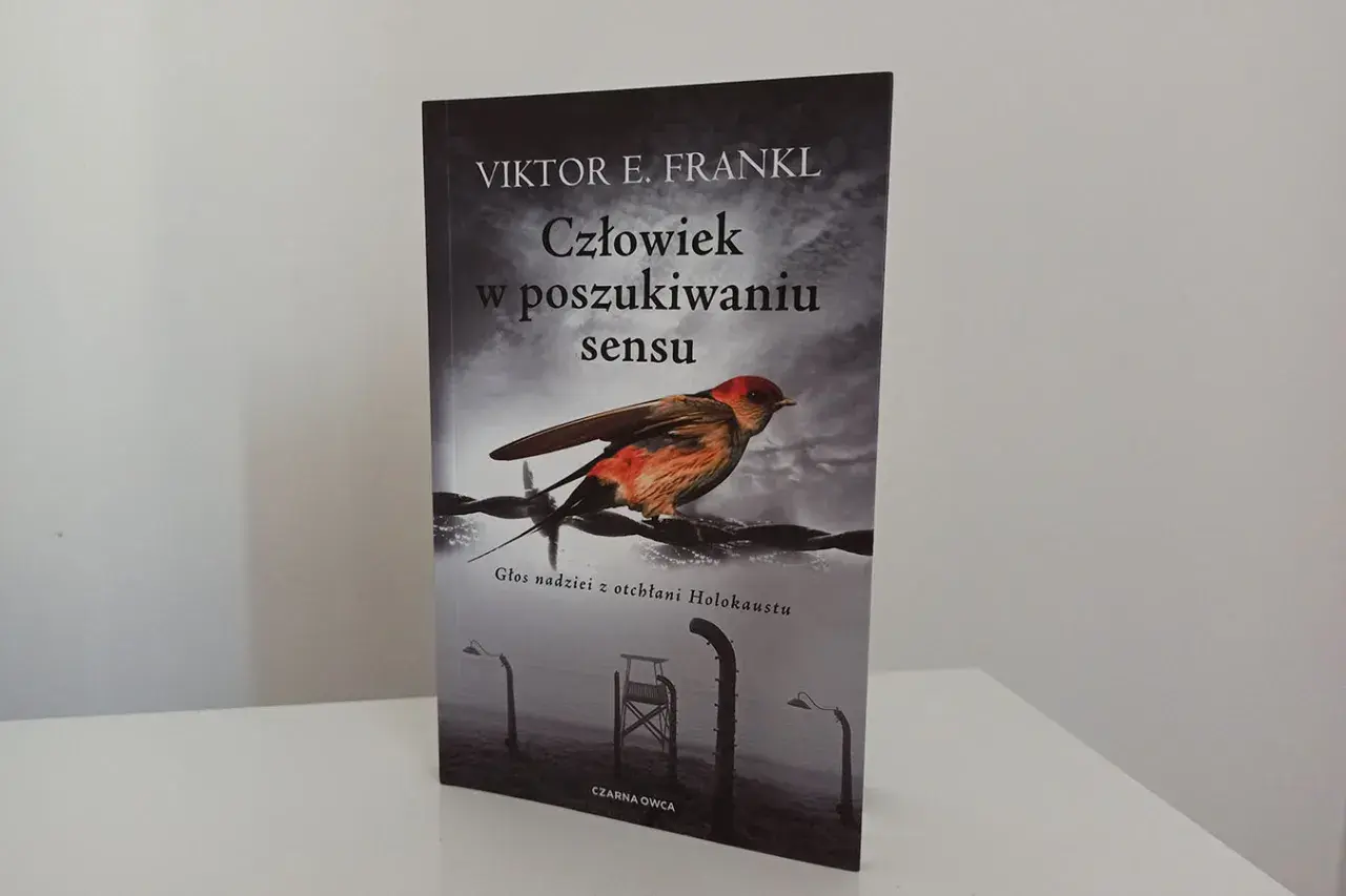 Okładka książki "Człowiek w poszukiwaniu sensu" Viktora Frankla. Ptak siedzi na drutach kolczastych, symbolizując nadzieję w mrocznych czasach.