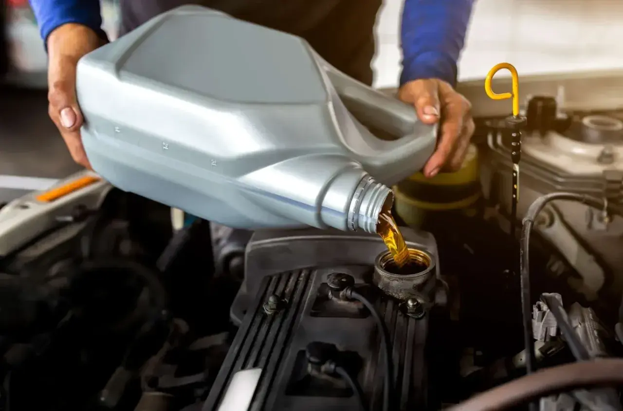 Mechanik wlewa olej do silnika. Dowiedz się, ile kosztuje wymiana oleju i filtrów robocizna.