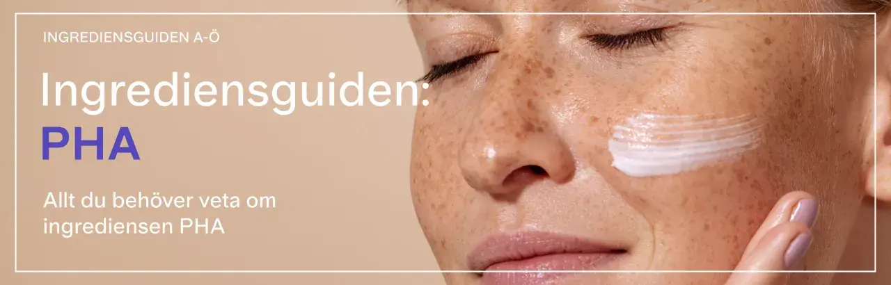 En närbild på en kvinna med fräknar som får en kräm applicerad på kinden. Texten lyder "Ingrediensguiden: PHA".
