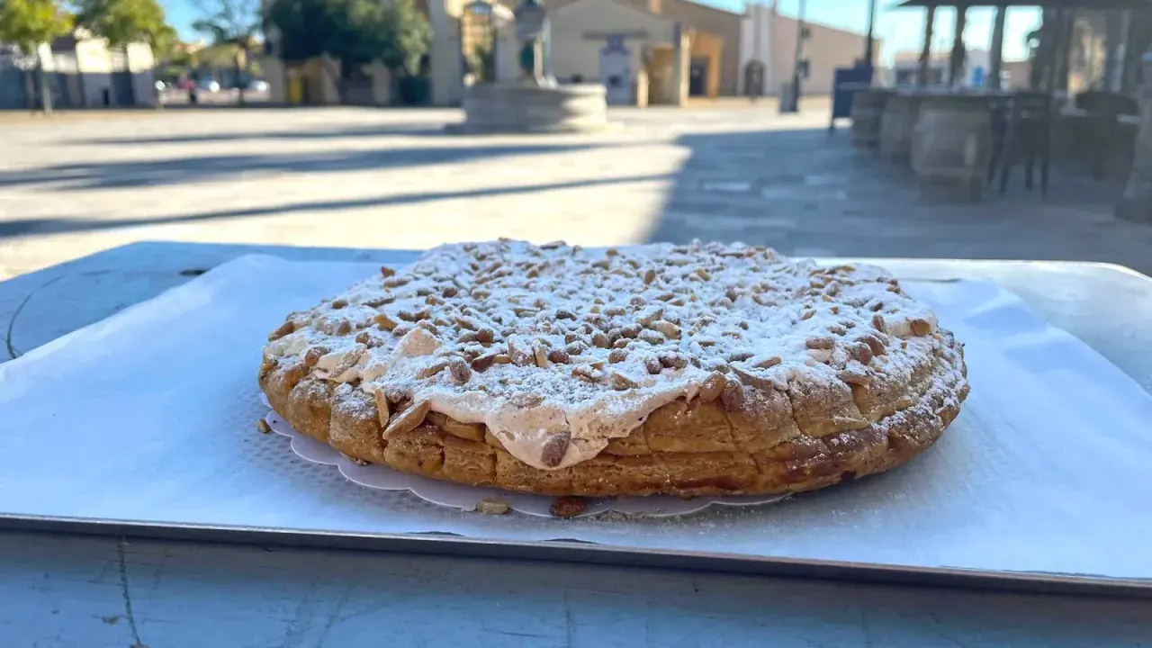 Tarte aux pignons de Gruissan, saupoudrée de sucre glace, sur une table ensoleillée.