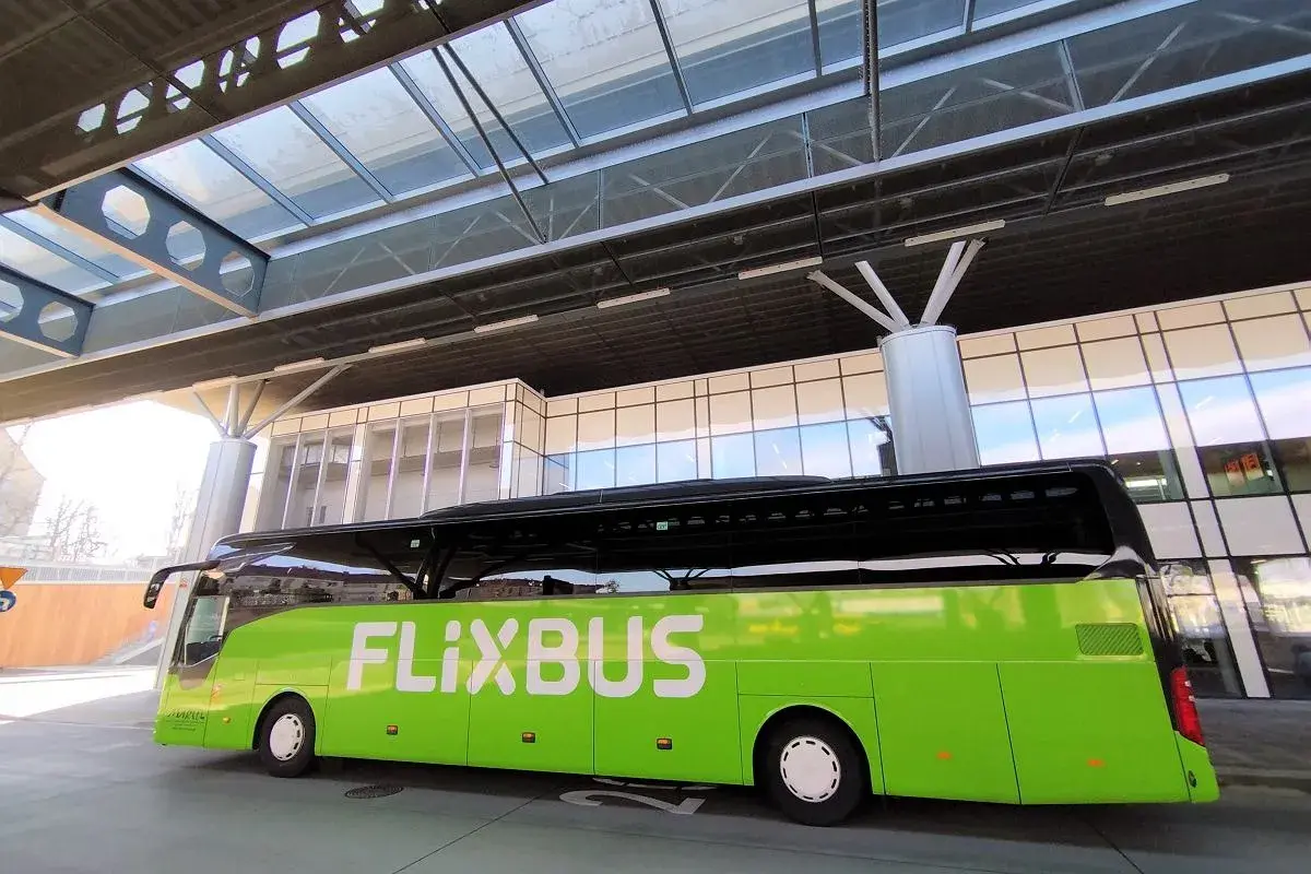 Zielony autobus FlixBus czeka na pasażerów na nowoczesnym dworcu. To idealne miejsce na rozpoczęcie podróży, bo flixbus przystanki są dobrze zorganizowane.