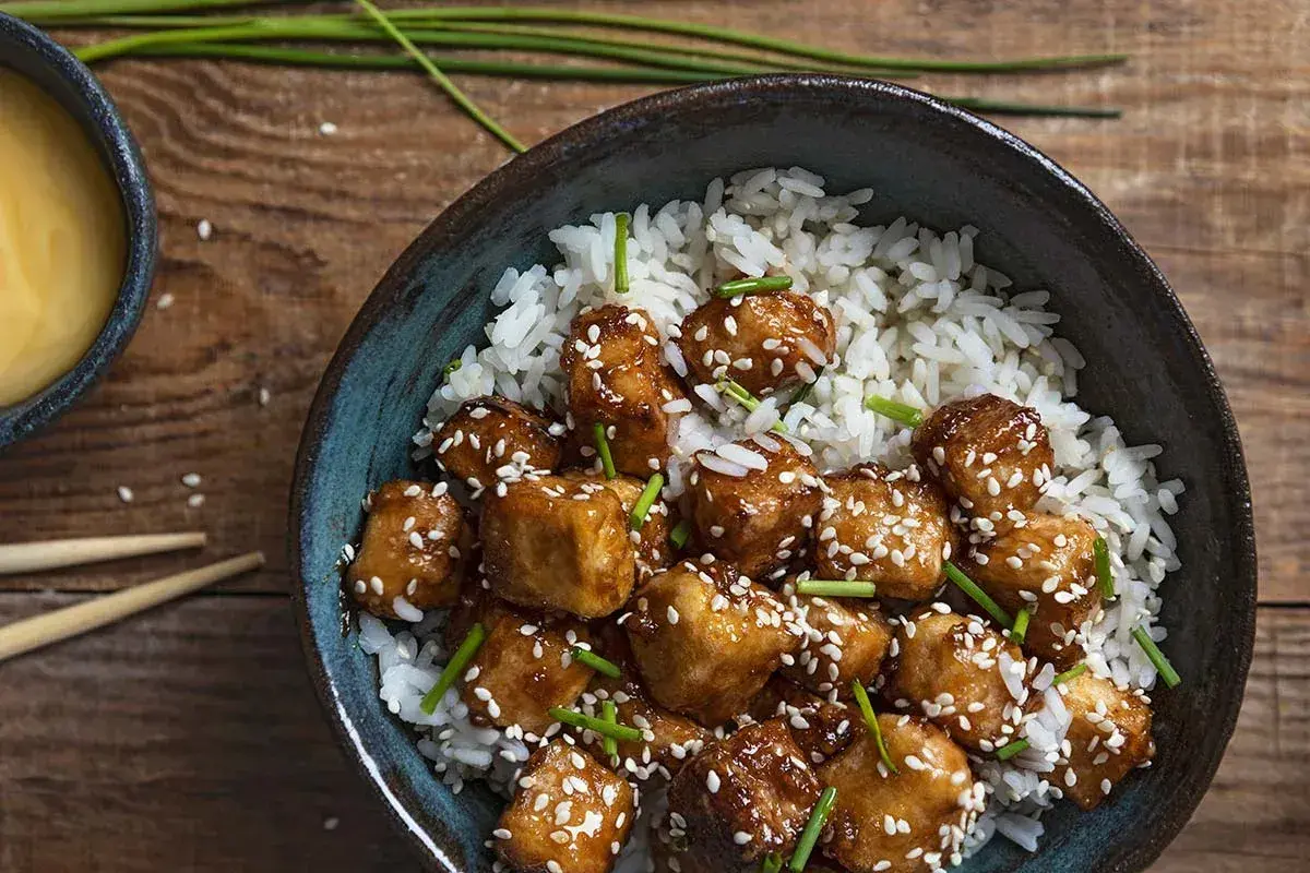 Pyszny stir fry z tofu, podany z ryżem i posypany sezamem. Idealny posiłek dla wegan.