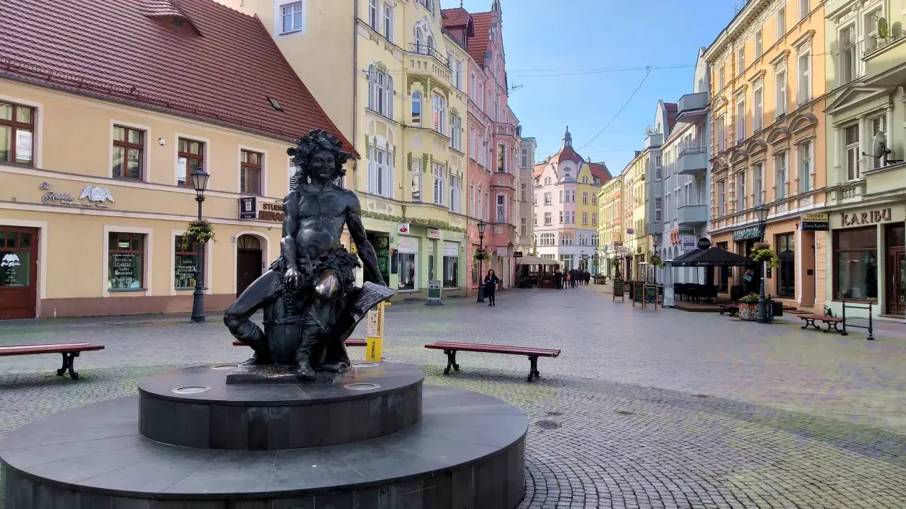 Pomnik w centrum miasta, kolorowe kamienice, ławki i brukowana ulica. Zielona Góra atrakcje turystyczne zachęcają do spacerów.