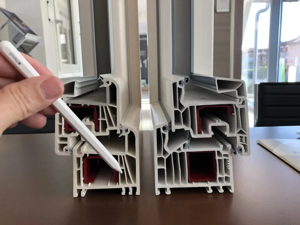 Sezione di profili per finestre in PVC che illustra i valori di isolamento termico e acustico.