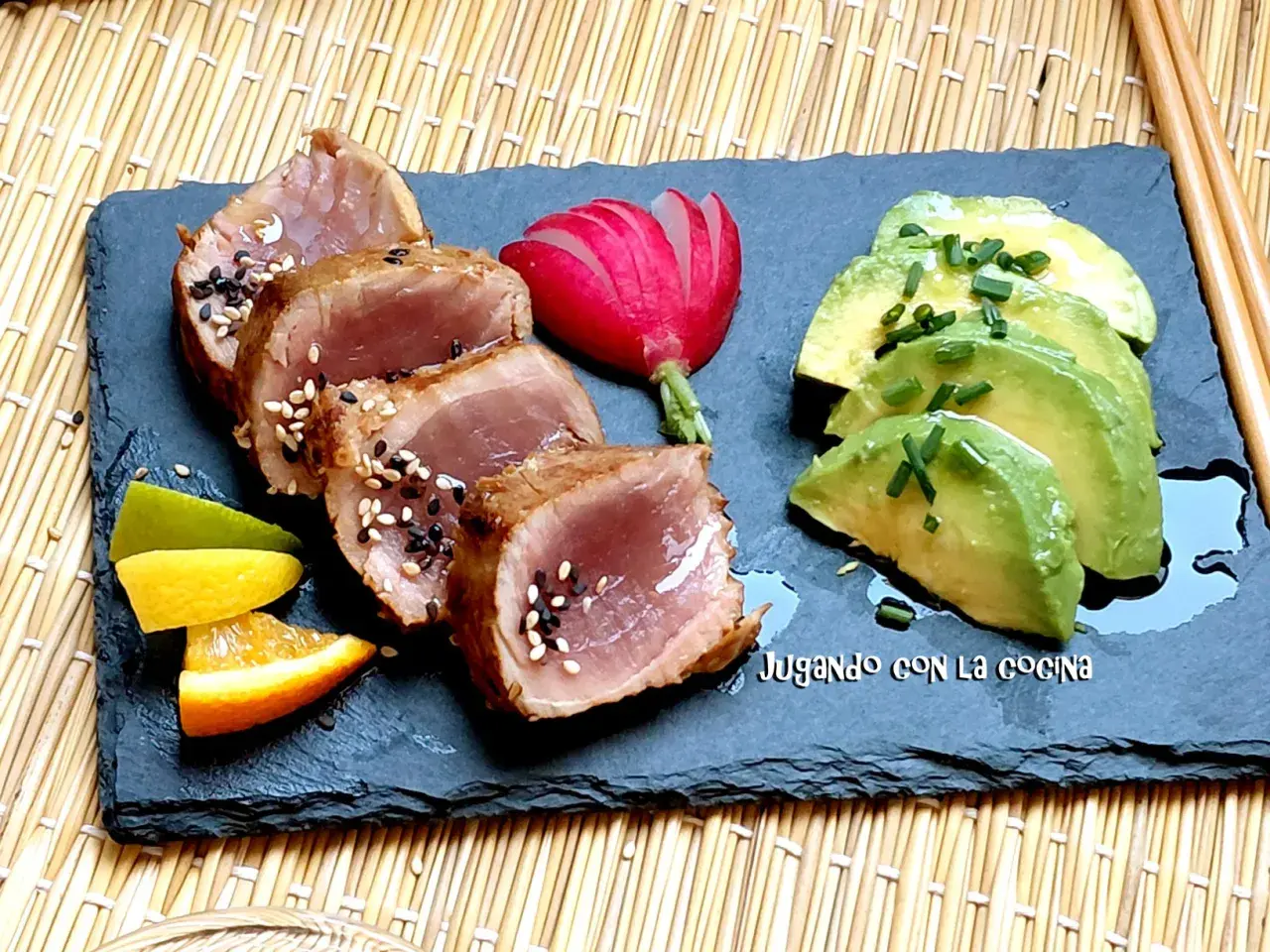 Tataki de bonito sellado con sésamo, acompañado de aguacate, rábano y cítricos.