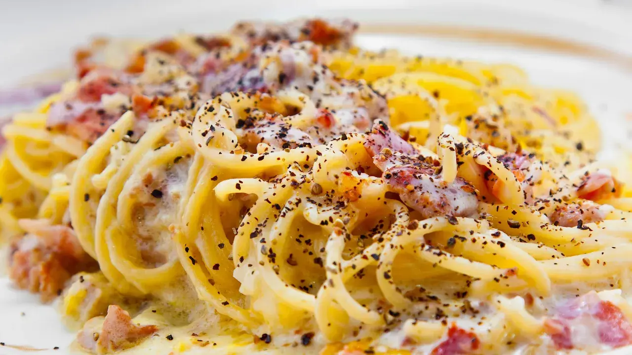 Spaghetti alla carbonara tradizionali, un piatto cremoso con guanciale croccante e abbondante pepe nero.