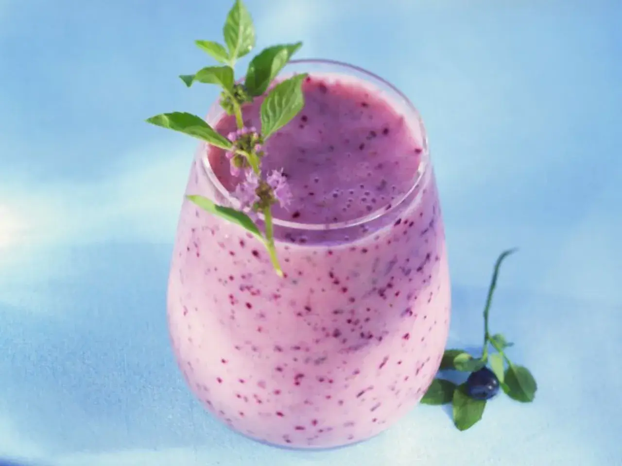 Erfrischender Beeren-Smoothie, perfekt für eine low carb Ernährung. Mit frischen Kräutern garniert.