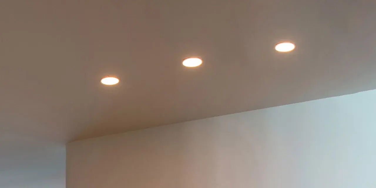 Trois spots encastrés éclairent un plafond. La lampe LED offre des avantages, mais il faut aussi considérer ses inconvénients.