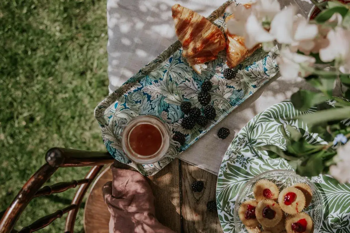 En härlig sommar fika med croissanter, björnbär och småkakor på ett vackert mönstrat fat.