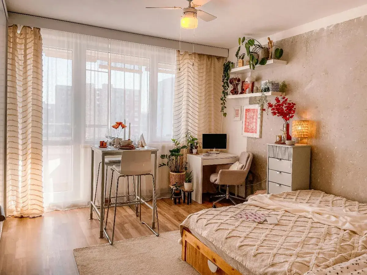 Idee per arredare una casa piccola: un angolo studio, un tavolo alto per mangiare e un letto accogliente, tutto in uno spazio compatto.