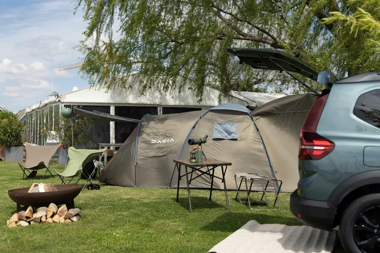 Dacia camper gotowe na przygodę. Namiot, krzesła i ognisko czekają na rozpalenie.