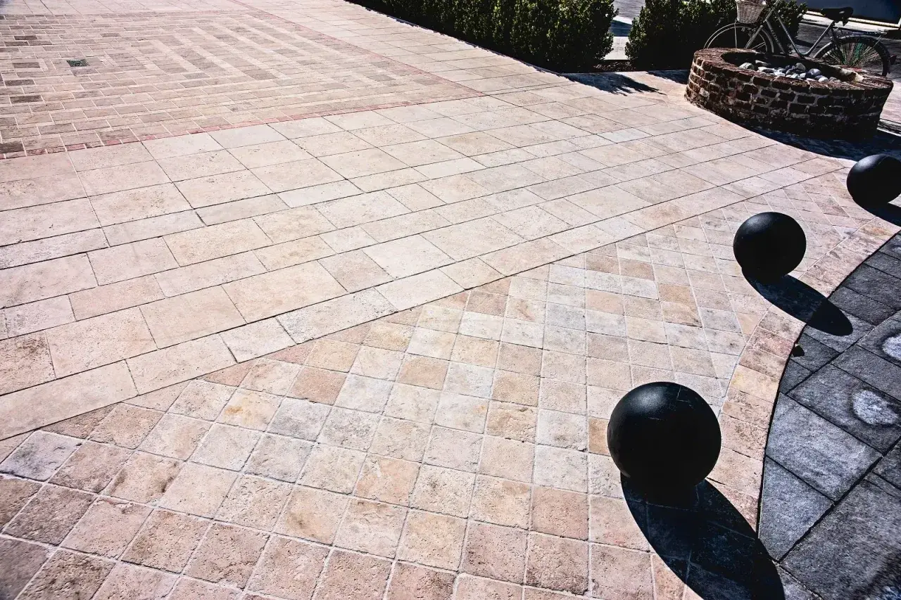 Pavimentazione esterna con eleganti mattonelle in pietra lavica, disposte in motivi geometrici che creano un suggestivo gioco di luci e ombre.