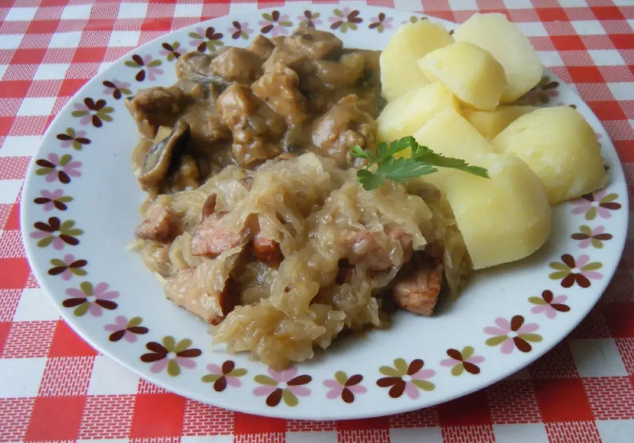 Pyszna kapusta kiszona gotowana z kawałkami mięsa i kiełbasy, podana z ziemniakami.