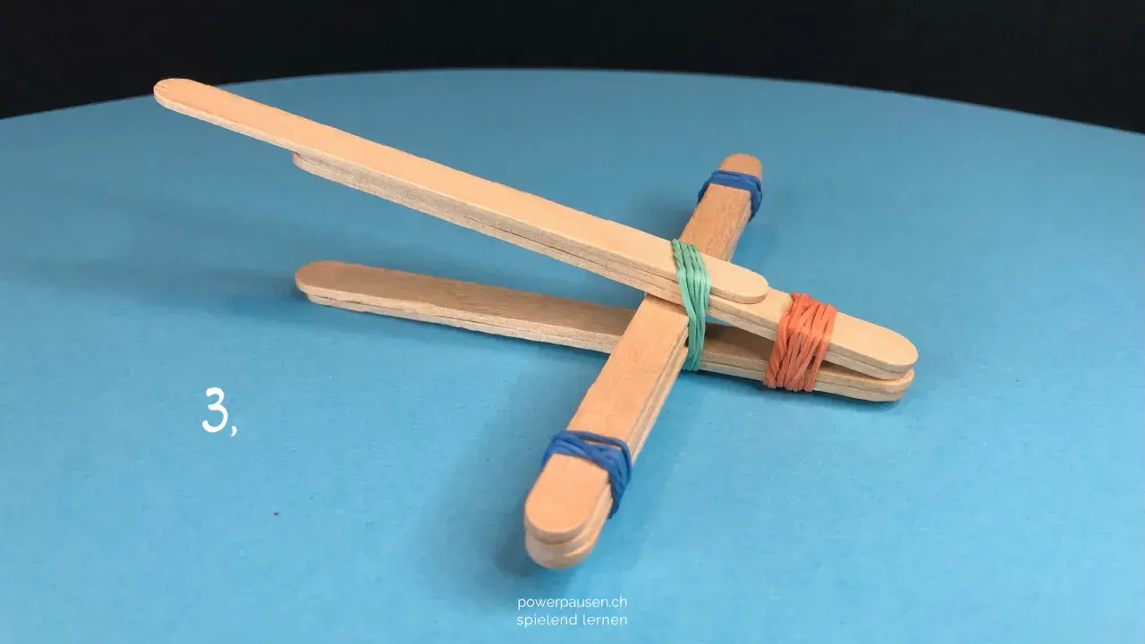 Schritt 3: Eine einfache Steinschleuder basteln aus Eisstielen und Gummibändern.