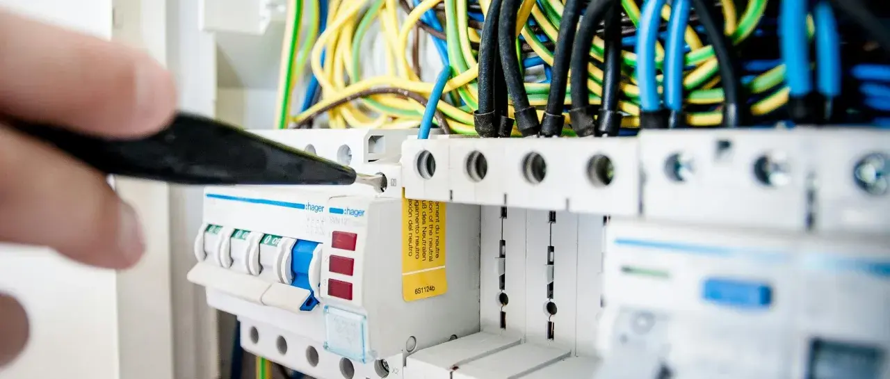 En elektriker arbetar med en elcentral, en viktig del för att kontrollera driftskostnad villa.