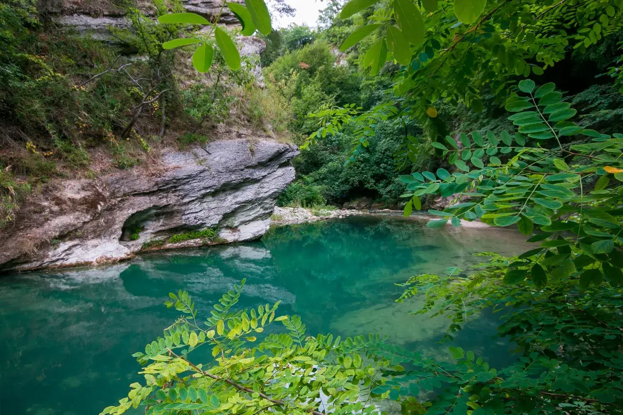 Acque cristalline e rocce imponenti in un angolo di paradiso naturale, un luogo che ricorda la purezza delle terme di Acquasanta.