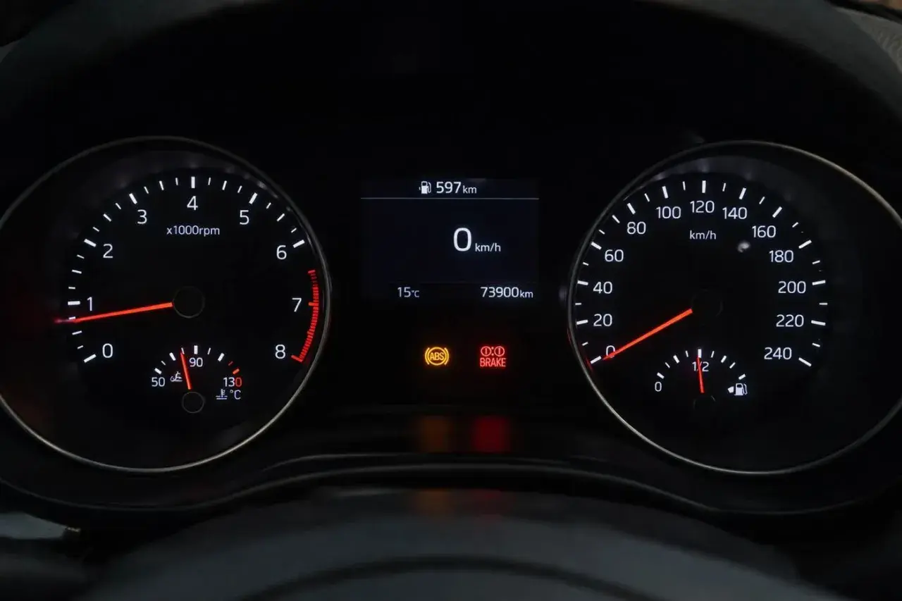 Cruscotto auto con tachimetro, contagiri e indicatori. La spia freni è accesa, segnalando un potenziale problema.