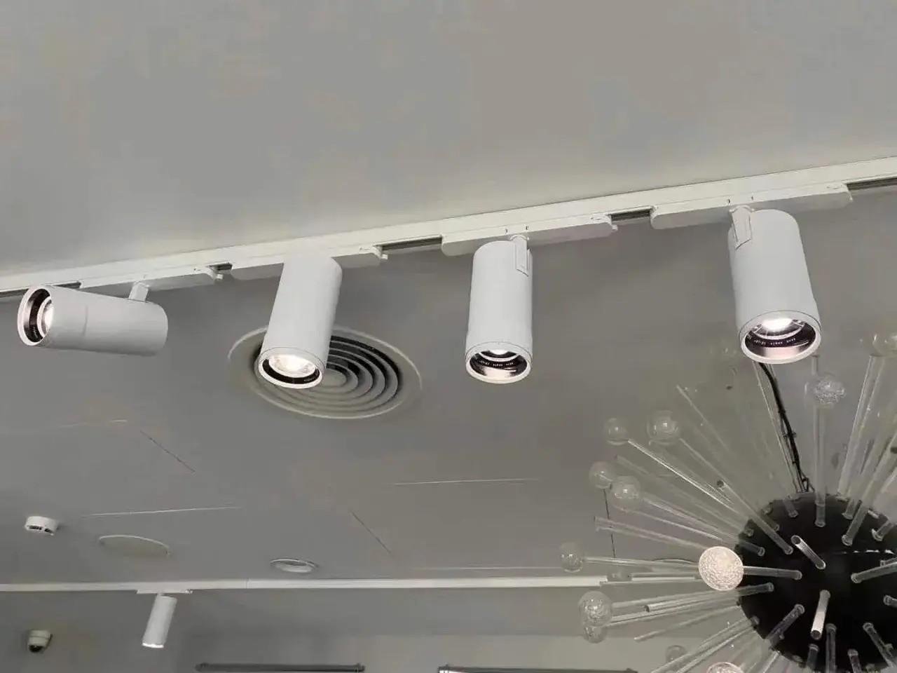 Barra focos techo blanca con focos cilíndricos dirigibles, iluminando un espacio moderno.