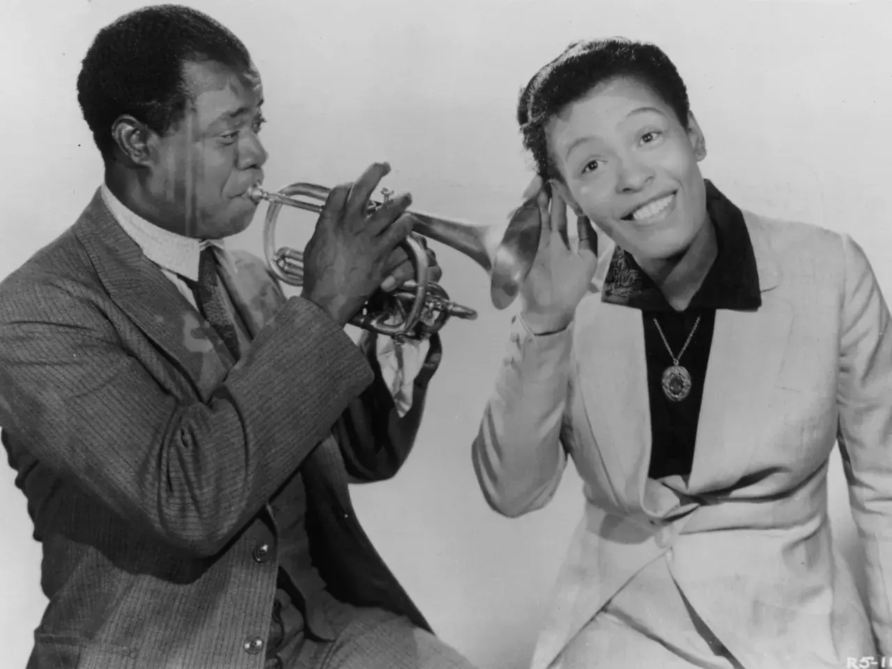 Louis Armstrong gra na trąbce, a Ella Fitzgerald słucha, zastanawiając się, co to scat.