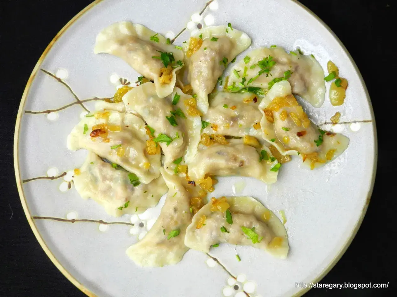 Pyszne pierogi z kaszą gryczaną bez sera, okraszone cebulką i posypane natką pietruszki.