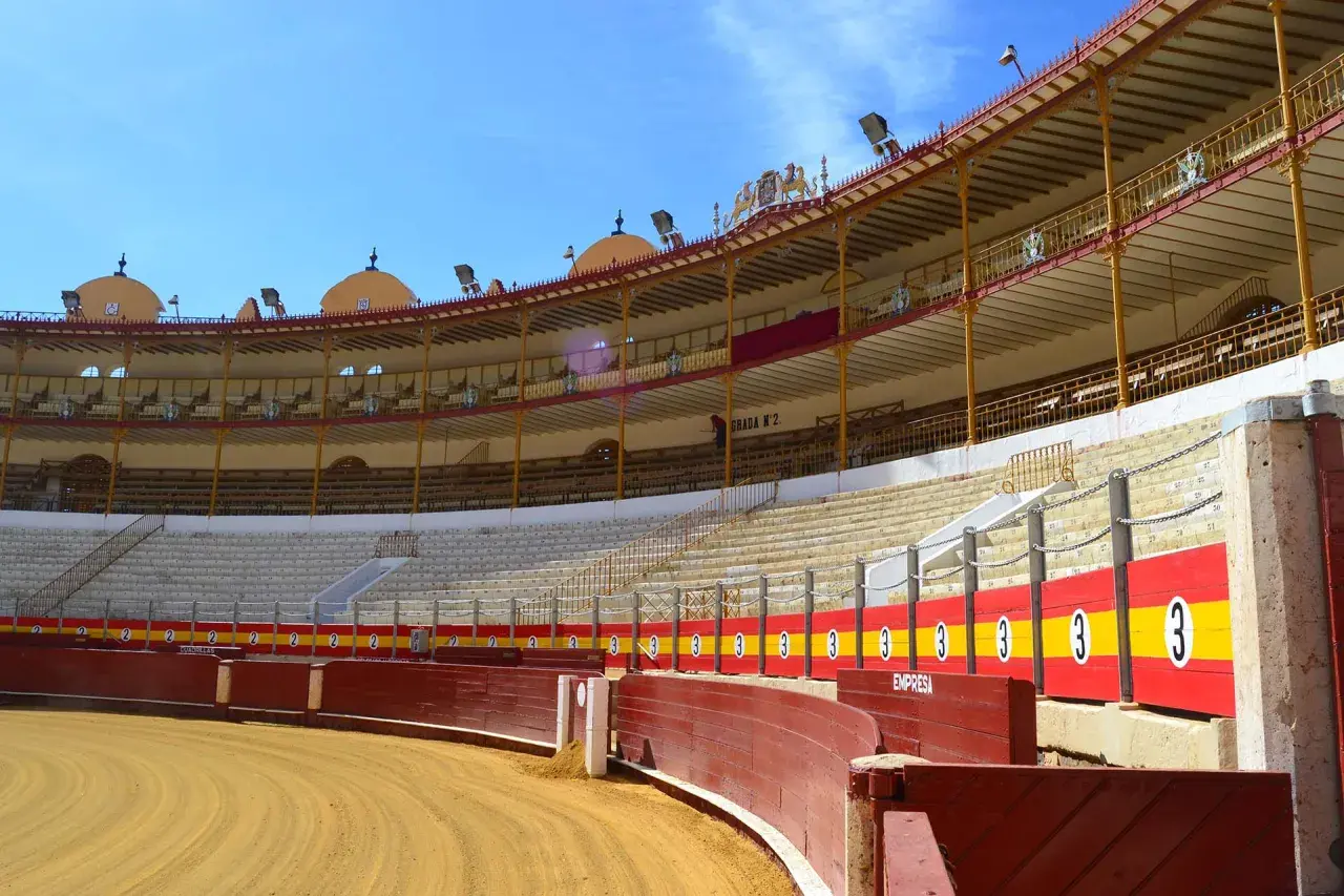 La grada de la plaza de toros, vacía y bajo un cielo azul, espera la emoción.