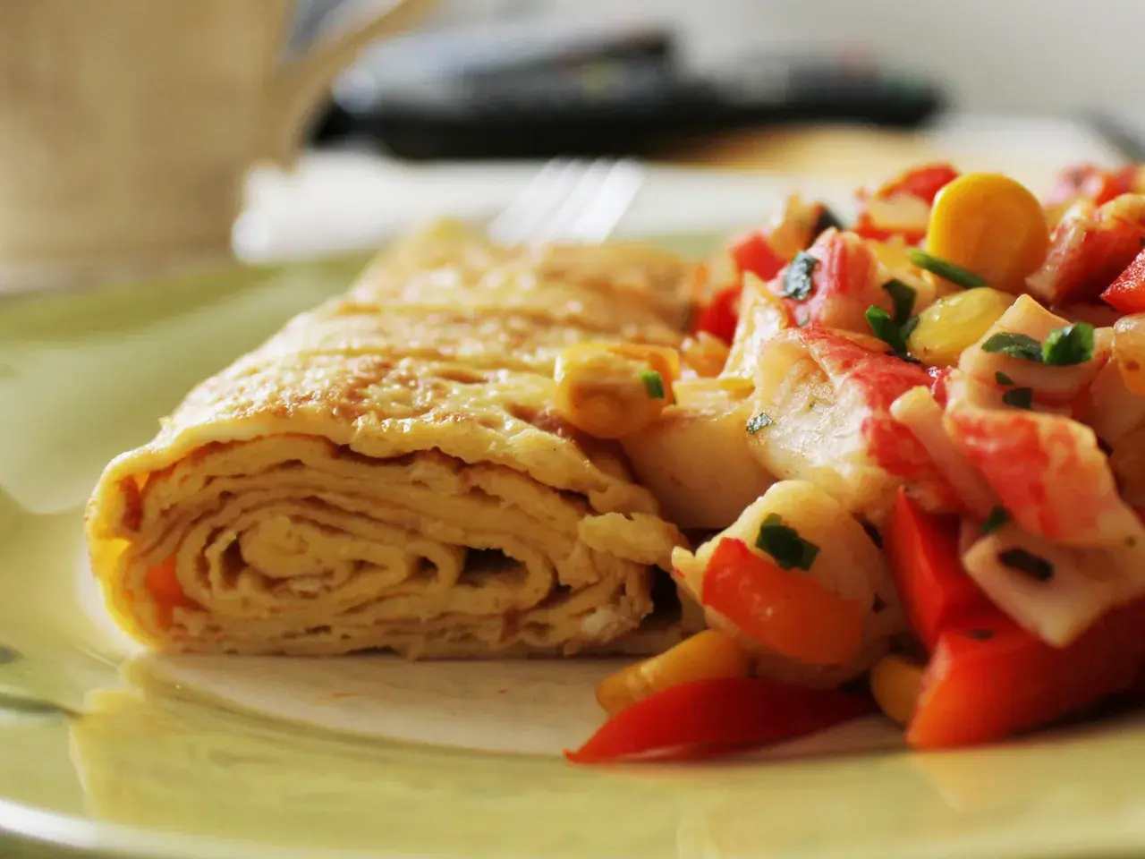 Zrolowany omlet po japońsku z kolorową sałatką z warzyw i surimi.