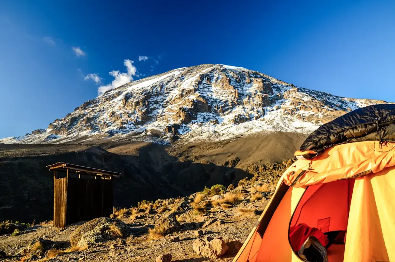 Zelt und Holzhütte am Kilimandscharo. Die beste Reisezeit Tansania ist ideal für dieses Abenteuer.