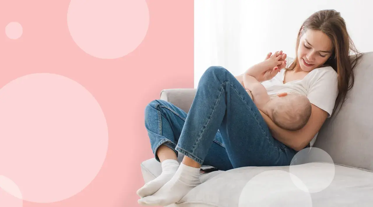 Szczęśliwa mama karmi piersią dziecko na kanapie. Laktacja po cesarce może być wyzwaniem, ale ta chwila pokazuje jej piękno.