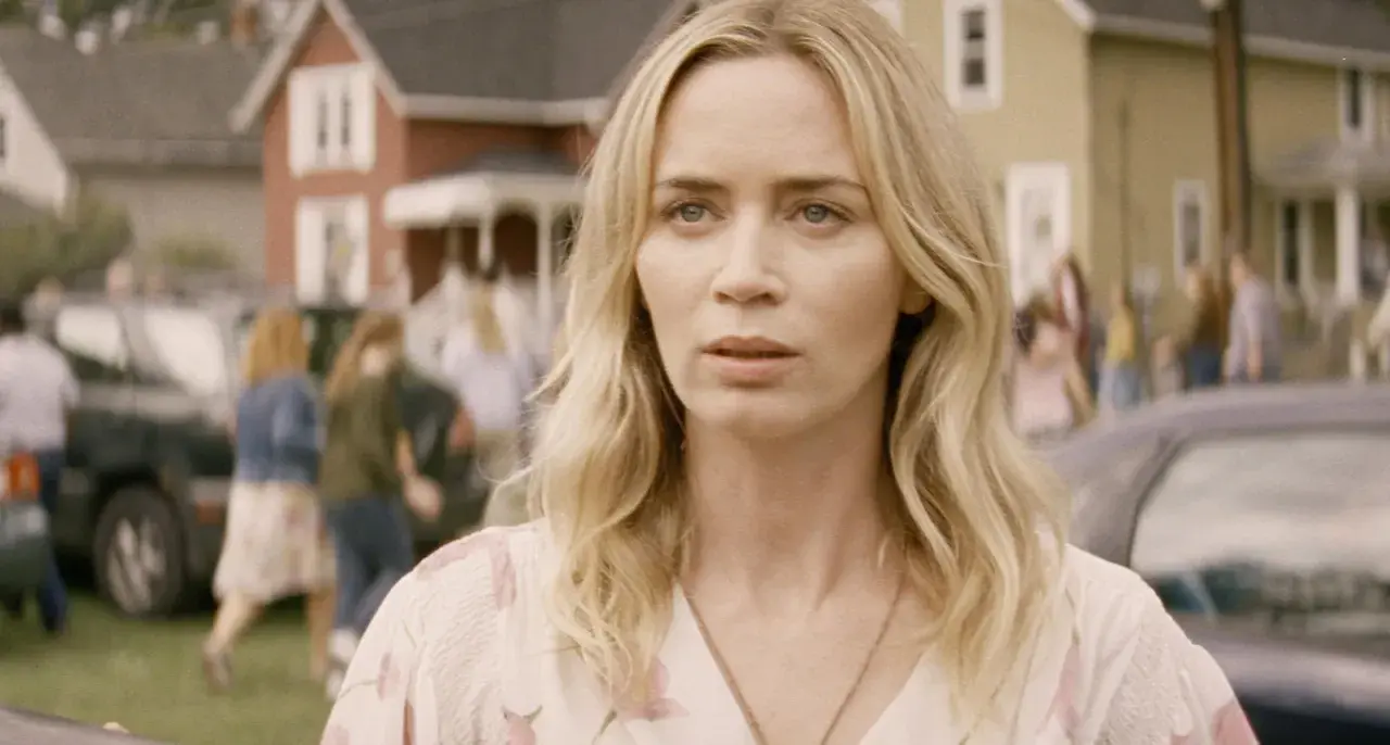 Emily Blunt i en scen från filmer med emily blunt. Hon ser orolig ut medan folk rör sig i bakgrunden.