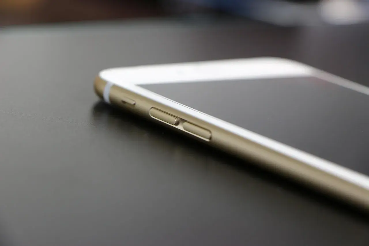 Złoty iPhone na ciemnym tle. Dowiedz się, jak znaleźć iPhone bez iCloud, gdy zgubisz urządzenie.