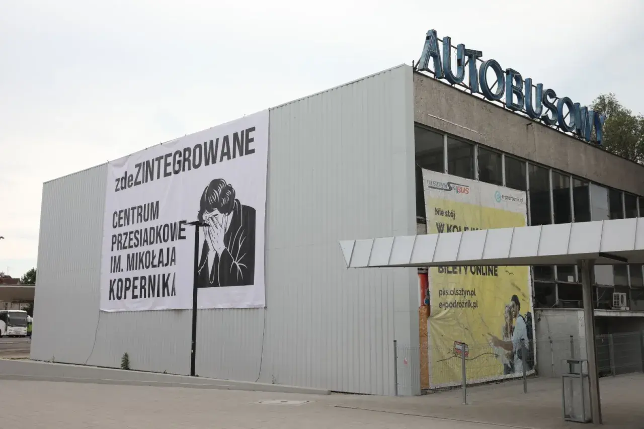 Budynek dworca autobusowego z banerem "zdeZINTEGROWANE CENTRUM PRZESIADKOWE IM. MIKOŁAJA KOPERNIKA".